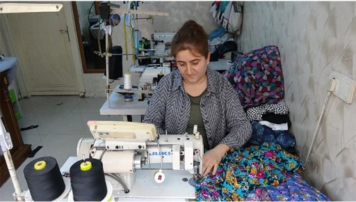 Kadın terzi kızlarının okuması i&ccedil;in makine başına ge&ccedil;ti