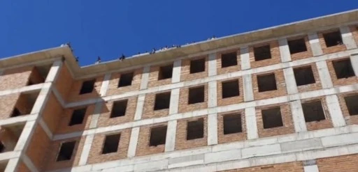Maaşlarını alamayan iş&ccedil;iler binanın tepesine &ccedil;ıktı